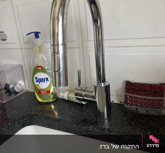 ברז מטבח עם חומרי ניקוי על השיש
